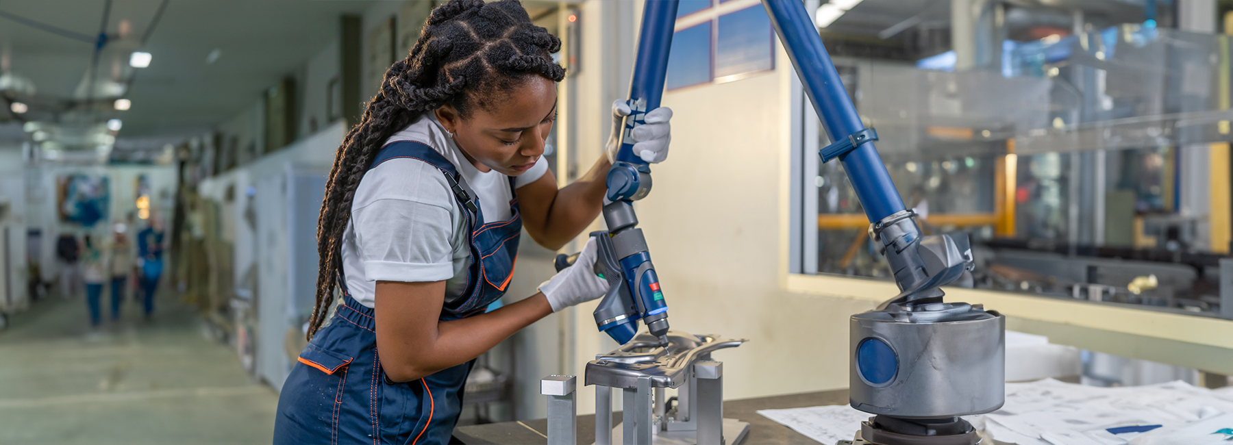 Female automation engineer wear a blue uniform with helmet safety inspection control a robot arm welding machine